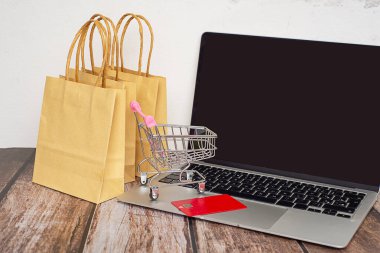  İnternetten konsept alışverişi ve teknoloji işi için el arabasında bilgisayar laptopunda alışveriş torbaları. Yüksek kalite fotoğraf