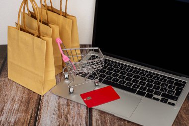  İnternetten konsept alışverişi ve teknoloji işi için el arabasında bilgisayar laptopunda alışveriş torbaları. Yüksek kalite fotoğraf