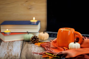 Sonbahar dekorlu sıcak bir fincan kahve, kitaplar ve dizüstü bilgisayar, şükran günü. Yüksek kalite fotoğraf