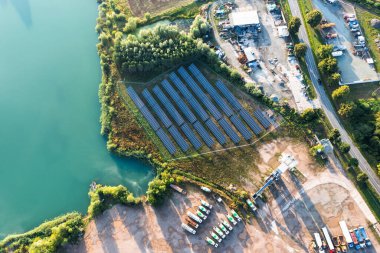 Mavi gölün yanındaki tesiste büyük güneşli bir park. güneş enerjisi