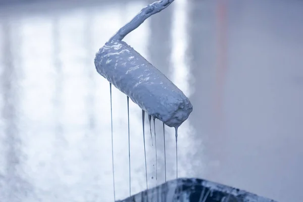 stock image Close-up of a paint roller, gray paint flows down the roller