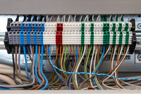 Electrical cabinet with multi-colored electric wires connected to automatic machines, close-up