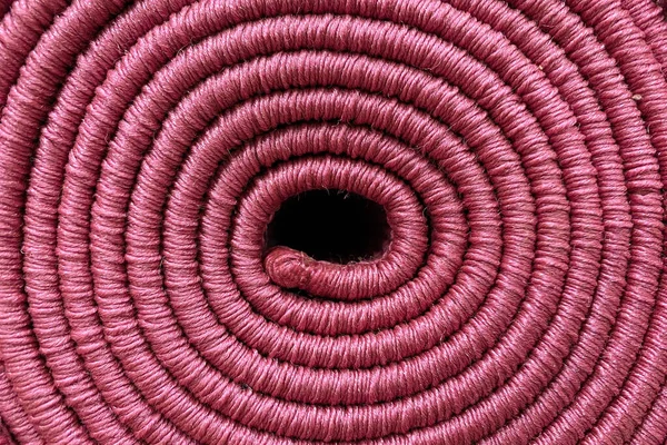 Rolled carpet, texture of spiral carpet in purple color, close-up