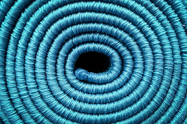 Rolled carpet, texture of a spiral carpet in blue, close-up