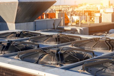 HVAC air conditioners on the roof of an industrial building, large fans on the roof of a house