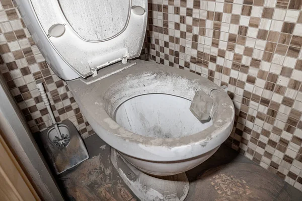Toz ve kir içinde kirli bir tuvalet, terk edilmiş tuvalet, sağlıksız koşullar.
