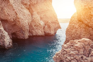 Kıyı uçurumlarında dalgalar kopuyor, sıcak yaz mevsiminde deniz manzarası