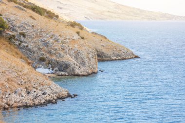 Açık güneşli bir günde mavi deniz ve kumlu dağ sırtı. Tatilde deniz manzarası, denizde ıssız adalar