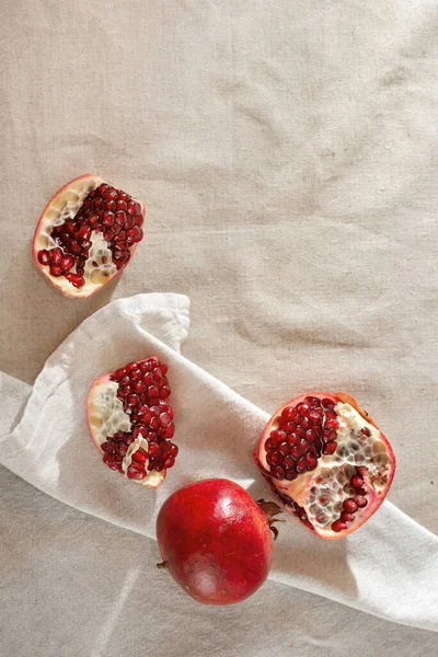 Lifestyle background with pomegranates on beige textile, fruits on a table, copy space