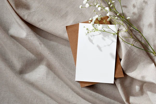 ミニマリストの花の結婚式の招待状またはグリーティングカード はがきテンプレート 空白の紙カードとベージュのニュートラルリネンの背景の花 — ストック写真
