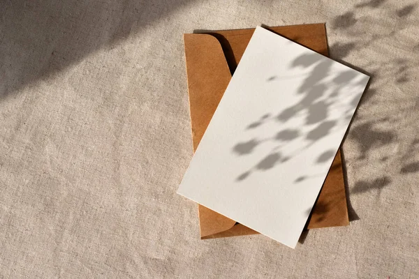 ミニマルでエレガントなナチュラルビジネスブランドのテンプレート 中性ベージュの背景に審美的な抽象的な太陽の影を持つ空白の紙のカード フラットレイ コピースペース — ストック写真