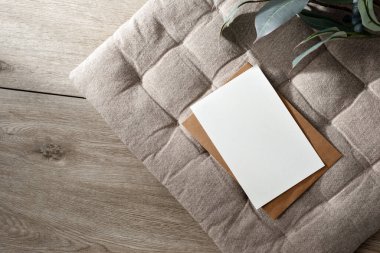 Boş kağıt maketi, minimalist estetik iş şablonu içinde bej rengi yastık arka planında kartpostal ve zarf, kopyalama alanı