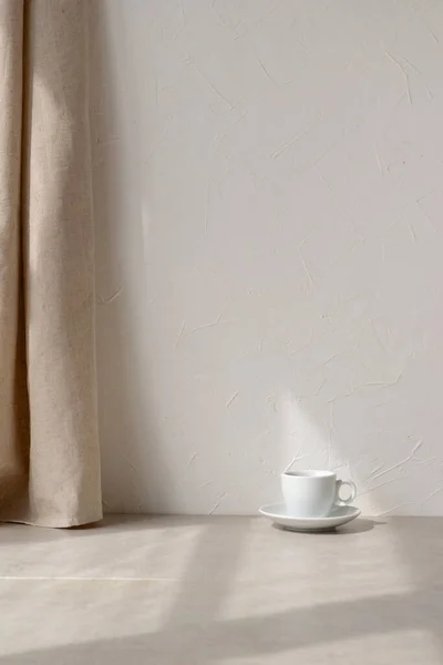 ミニマルなインテリアデザイン構成 ベージュの石テーブルの上のコーヒーカップ リネンカーテン 空の白い壁の背景と幾何学的な日光影 審美的な中立的な家の部屋の背景 コピースペース — ストック写真