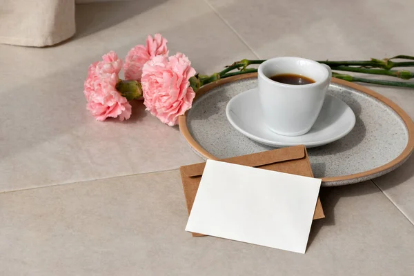 空白の紙カード はがきのモックアップ コーヒーカップ 太陽の光の下でベージュの背景に花 審美的な休日の挨拶や結婚式のデザインテンプレート — ストック写真