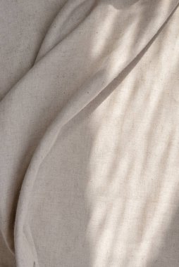 Doğal güneş ışığı gölgeleriyle kaplanmış bej kumaş dokusu. Tarafsız yaşam tarzı bohem arkaplan