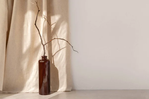ホームルームインテリア製品のためのミニマリストテンプレート ベージュテーブルや床に木製の枝を持つ花瓶 リネンカーテンと空の白い壁に審美的な日光の影 — ストック写真