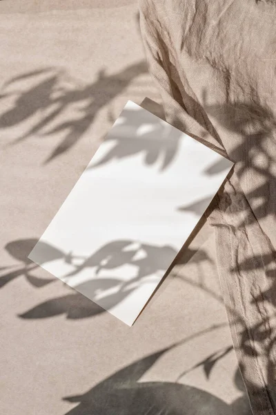 在中性米色亚麻布背景上的空白纸制卡片造型 具有美观的花卉阳光阴影 可持续的商业品牌模板 婚宴请柬设计 — 图库照片