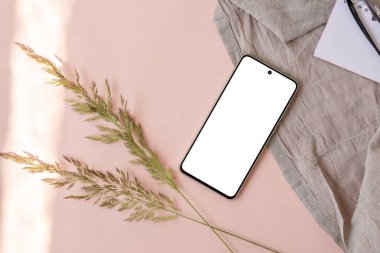 Estetik yaşam tarzı marka şablonu, boş akıllı telefon ekranı maketi, keten kumaş, açık pembe arka planda çayır çimeni, boşluk kopyalama