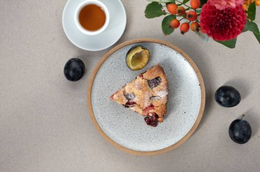 Bir parça Meşhur Erikli Turta, tabakta turta, bir fincan çay ve çiçekli vazo. Geleneksel Amerikan meyveli pasta fırını, lezzetli sabah kahvaltısı..