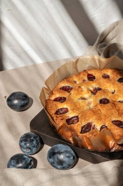 Ev yapımı meyveli turta, bej bir masada orjinal erikli turta ve arka planda güneş ışığı gölgesi. Tatlı lezzetli pastane.