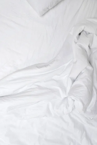 Aesthetic neutral white crumpled cotton textile background. Messy bedding, blanket and sheet.