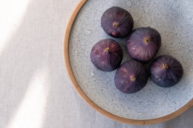 Tabaktaki konserler, doğal güneş ışığı gölgeli bej keten masa örtüsü, düz yatış, kopyalama alanı.