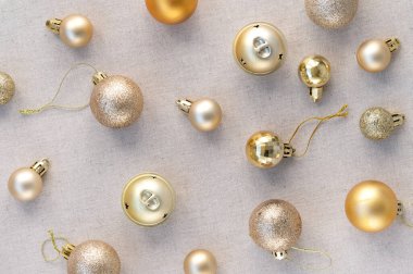 Altın pastel Noel 'li estetik zarif şenlik deseni, yeni yıl süsleme topları, nötr bej keten kumaş arka planında süsler..