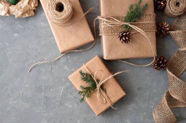Noel, sürdürülebilir boks ve ambalajlar sunar. Tatil kutlaması hazırlıkları. Çam ağacı dalı, koni ve kenevirle süslenmiş el yapımı kağıt kutular. Ekolojik tasarım, kopyalama alanı olan arkaplan