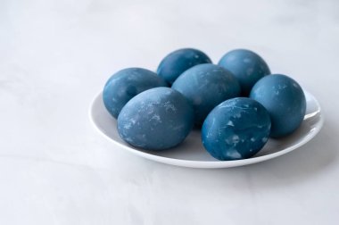 Tarafsız mermer masa zemininde mavi Paskalya yumurtaları, geleneksel Paskalya bayramı ev yapımı dekoratif yemekler, yumuşak seçici odak.