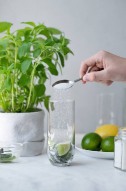 Kaşık kaşık, bardağa limon ve nane yapraklı şeker doldurma, mojito kokteyli hazırlama, ev yapımı ferahlatıcı yaz içeceği hazırlama..