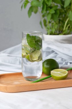 Mojito kokteyli bardakta, limonda, saman içerken, nane şekeri beyaz mermer masa arkasında..