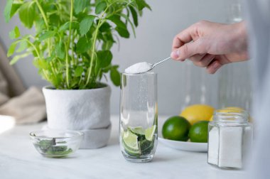 Ev yapımı mojito yapma süreci, bardağa nane ve limonla şeker dökme yaz taze kokteyli hazırlama, mutfak mutfağı..
