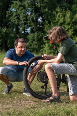Babası ve genç oğlu bisikletten bıktılar, insanlar kırsalda bisiklet sürerken mola verdiler, aile yazları açık hava aktiviteleri..