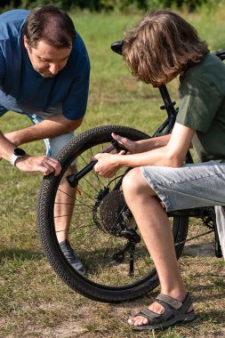 Babası ve küçük oğlu dışarıda bisiklet tekerleklerinden bıkmışlar..