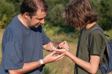 Babası ve genç oğlu kırsalda yürürken buldukları küçük bir salyangozu tutuyorlar..