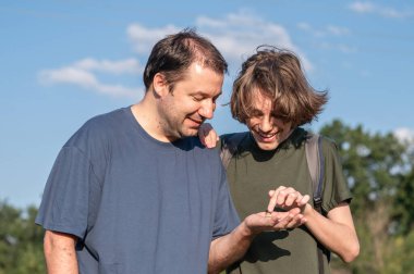 Genç bir çocuk ve babası, doğada küçük bir salyangoz tutuyorlardı. Konuşuyorlardı ve gülümsüyorlardı. Aile birliktelikleri ve arkadaşlıkları..