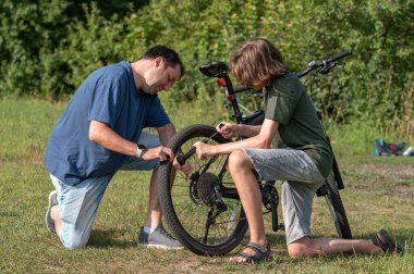 Genç bir çocuk ve babası doğada bisiklet tekerleğinden bıktılar..