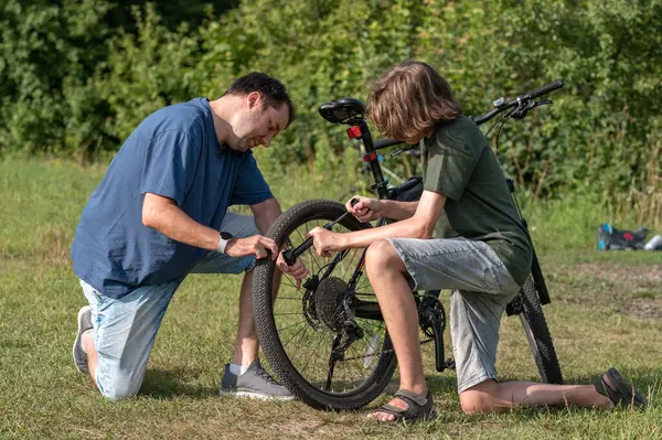 Genç bir çocuk ve babası doğada bisiklet tekerleğinden bıktılar..