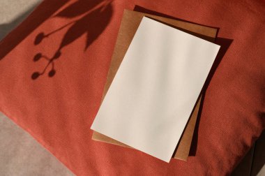 Sonbahar tebrik kartı ya da düğün davetiyesi tasarım şablonu, boş kağıt desen modeli, terasotta kırmızı desenli, estetik güneş ışığı gölgeli kahverengi zarf..