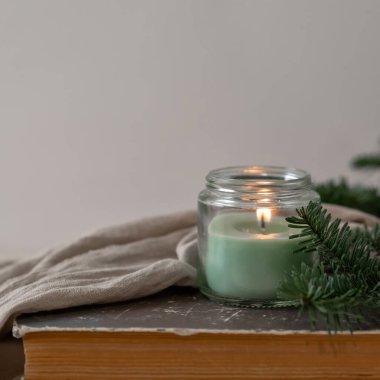 Kokulu mum ışığı, bitki, keten kumaş ve kitap ile zarif nötr bir arkaplan..