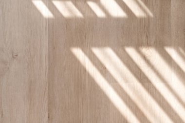 Yumuşak geometrik güneş ışığı gölgeleriyle doğal ahşap zemin dokusu, modern zemin kaplama materyali..