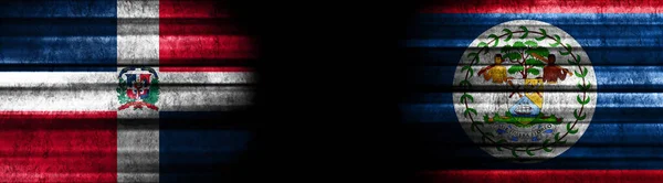 ドミニカ共和国と黒い背景のベリーズの旗 — ストック写真