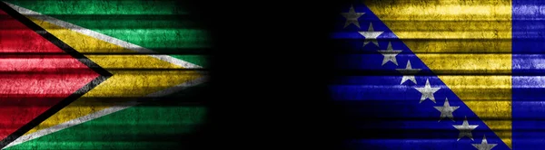黒い背景のガイアナとボスニアとヘルツェゴビナの旗 — ストック写真