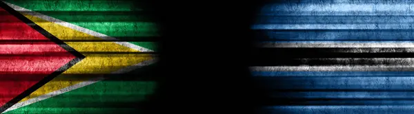 黒い背景のガイアナとボツワナの旗 — ストック写真