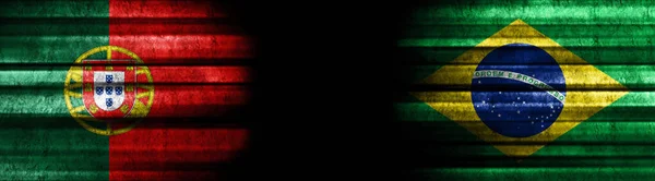 ブラックバックグラウンドのポルトガルとブラジルの旗 — ストック写真