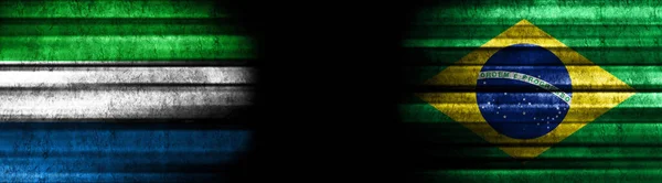 ブラックバックグラウンドのシエラレオネとブラジルの旗 — ストック写真