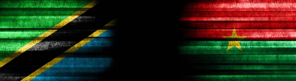 黒い背景にタンザニアとブルキナファソの旗 — ストック写真
