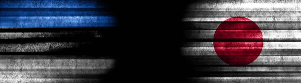 Estonia and Japan Flags on Black Background