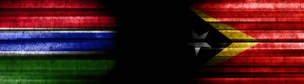 ガンビアと東ティモールの旗 黒い背景 — ストック写真