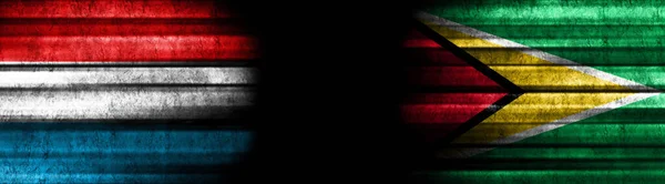 ブラックバックグラウンドのルクセンブルクとガイアナの旗 — ストック写真